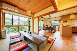 a large living room with a table and a kitchen at 湖の辺の宿時翠 in Yamanakako