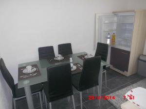 una sala da pranzo con tavolo e sedie nere di Frankfurt Airport & Fair Apartment a Kelsterbach