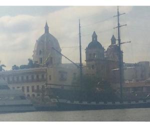 ein Boot im Wasser mit einem Gebäude im Hintergrund in der Unterkunft III NICE 2 BEDROOM APARTMENT Bocagrande in Cartagena de Indias