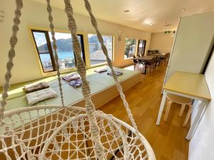 a rope swing in a room with a table at Guesthouse All you need in Shimoda
