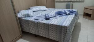 - un lit avec des serviettes bleues dans une chambre dans l'établissement Apartamento Diamante, à Águas de Lindóia 14 autres photos