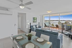a living room with a blue couch and a table and chairs at Spectrum Holiday Apartments in Gold Coast
