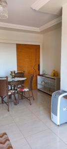 een eetkamer met een tafel en stoelen en een koelkast bij Apartamento Diamante in Águas de Lindóia