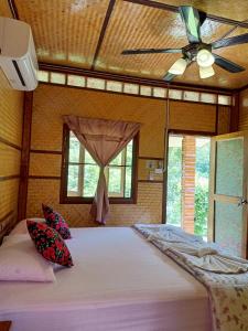 Ban Pha Saeng LangBansuanphutarn的一间卧室配有一张大床和吊扇