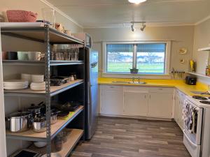 a kitchen with yellow counters and a refrigerator at The Cottage @ Aranui in Wairoa