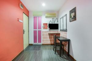 a living room with a table and a tv at OYO 90282 Hotel Taj Inn, Seksyen 7 in Shah Alam