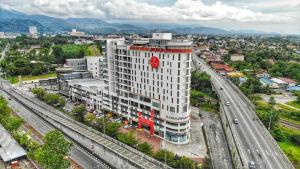 a large white building with a red sign on it at Sense Hotel Taiping in Taiping