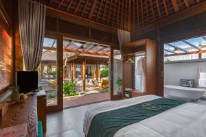 ein Schlafzimmer mit einem Bett, einer Badewanne und einem TV in der Unterkunft Alam Wayang Ubud - CHSE Certified in Ubud