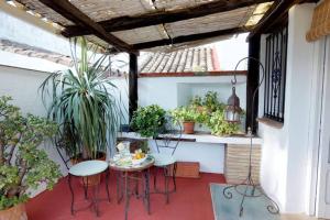 een patio met een tafel, stoelen en planten bij La casa del piano - Beautiful 18th century house with courtyard & pool in Jimena de la Frontera