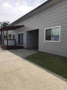 ein Haus mit einer Garage neben einer Auffahrt in der Unterkunft Secret at Sussex Inlet Units in Sussex inlet