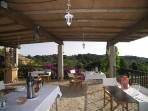 a patio with white tables and chairs with a view at Agroturisme Es Picot in Son Macia