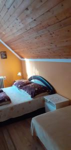 two beds in a room with a wooden ceiling at Éva vendégház in Egerszalók +18 photos