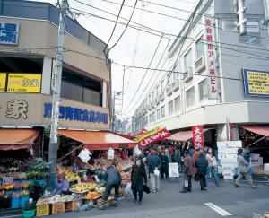 a group of people walking around a market with fruits and vegetables at Hotel Central Sendai in Sendai
