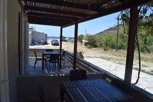 Eine Veranda mit Tisch und Stühlen und Blick auf das Meer in der Unterkunft Camping Kea in Pisses