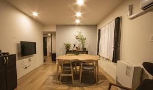 UCHI Susukino 5.7 في سابورو: غرفة طعام مع طاولة وغرفة مع تلفزيون