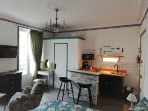a living room with a couch and a kitchen with a counter at Le DINGSON in Arromanches-les-Bains
