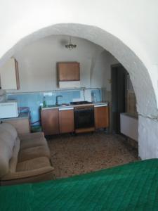 een woonkamer met een bank en een keuken bij Trullo Francisco in Martina Franca