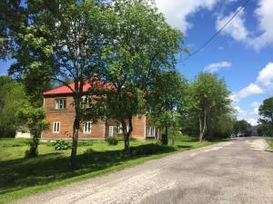 a brick house with trees on the side of a road at Allika külalistemaja 