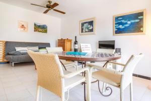 ポルト・デ・ソリェルにあるPuerto Rico Apt. Port de Sóllerのテーブルと椅子のあるダイニングルームとリビングルーム