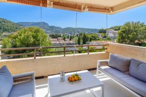 a balcony with chairs and a table with fruit on it at Puerto Rico Apt. Port de Sóller in Port de Soller