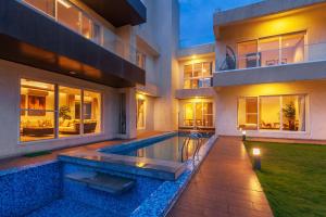 a house with a swimming pool in front of it at Villa Azul by StayVista, offering A snooker table, Terrace, Swimming pool & A spacious lawn with a charming gazebo for a perfect getaway in Lonavala