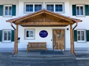 une porte en bois avec un banc devant le bâtiment dans l'établissement Der Obere Wirt zum Queri, à Andechs