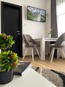 ein Wohnzimmer mit einem Tisch und Stühlen sowie einem TV in der Unterkunft Restoran,,Vuk,, Tršić in TrÅ¡iÄ‡