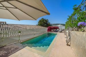 a swimming pool with an umbrella next to a house at Marbat Plus in Port de Soller