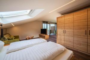 1 dormitorio con 1 cama grande y TV en Ferienwohnung Cuve en Merano