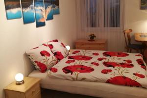 a bedroom with a bed with red flowers on it at Haus Mezzaselva - CharmingStay in Flumserberg