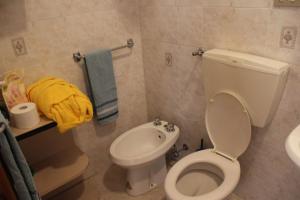 a bathroom with a white toilet and a sink at La casa di Rina in Ponzone
