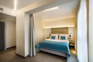 a bedroom with a large bed with blue sheets at Hotel Marina - by Liburnia Hotels & Villas in Mošćenička Draga +64 photos