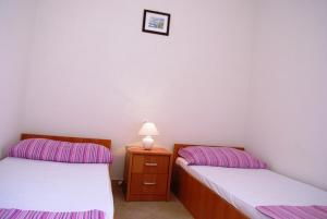 Cette chambre comprend deux lits et une table avec une lampe. dans l'établissement Apartment in Pisak with sea view, terrace, air conditioning, WiFi (3817-3), à Pisak
