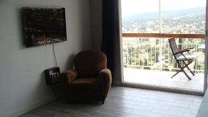 a living room with a chair and a large window at Appartement Cassis vue mer d'exception in Cassis