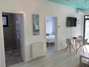 a living room with a table and chairs and a room at Ela's Apartment in Mamaia Sat/Năvodari