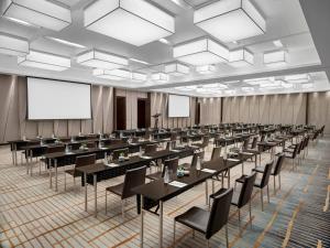 a conference room with tables and chairs and a projection screen at New World Saigon Hotel in Ho Chi Minh City +91 photos