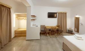 a room with a table and chairs and a bedroom at AGNADEMA Luxury Residences in Schinoussa