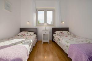 - 2 lits dans une chambre avec 2 fenêtres dans l'établissement Apartment Lucija, Stinjan, à Pula