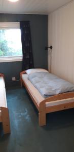 ein Schlafzimmer mit einem Bett in einem Zimmer mit einem Fenster in der Unterkunft Granheim Hytte med 2 soverom in Birkeland