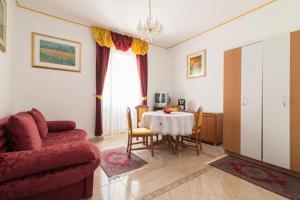 Una sala de estar con una mesa y un sofá rojo. en Ferienwohnung IUSAF-123-5, en Savudrija