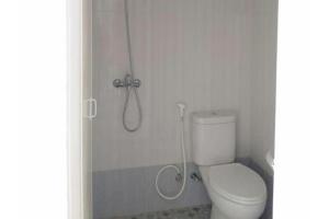 een badkamer met een douche en een toilet. bij RedDoorz @ Komplek MMTC Deli Serdang in Pulauberayan Dadap