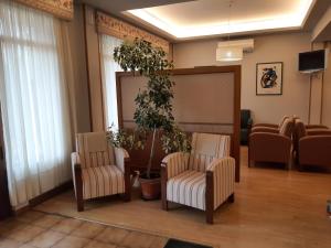 una sala de espera con 2 sillas y una planta en Hotel Las Dunas, en Somo