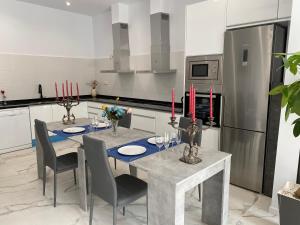 a kitchen with a table and chairs with red candles at Camp Nou Nueva Casa in El Arrabal