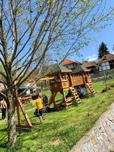 a boy playing in a playground with a tree house at Restoran,,Vuk,, Tršić in TrÅ¡iÄ‡