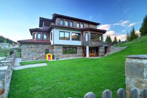 a house on a hill with a green yard at Stoykite-Pamporovo Nature Retreat in Stoykite