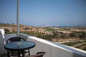a table and chairs on a balcony with a view at AGNADEMA Luxury Residences in Schinoussa
