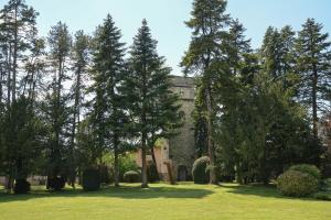 a group of trees in front of a castle at Cit'Hôtel La Résidence in Villebois