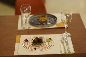 a plate of food on a table with two wine glasses at Sundia Exclusive By Liberty Fethiye Adults Only in Fethiye