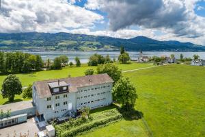 z góry widok na budynek z polem i jeziorem w obiekcie Rapperswil-Jona Youth Hostel w mieście Rapperswil-Jona