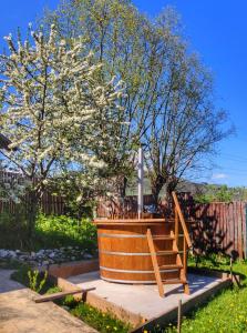 un árbol con flores blancas y una escalera de madera en Pensiune Maria en Rucăr